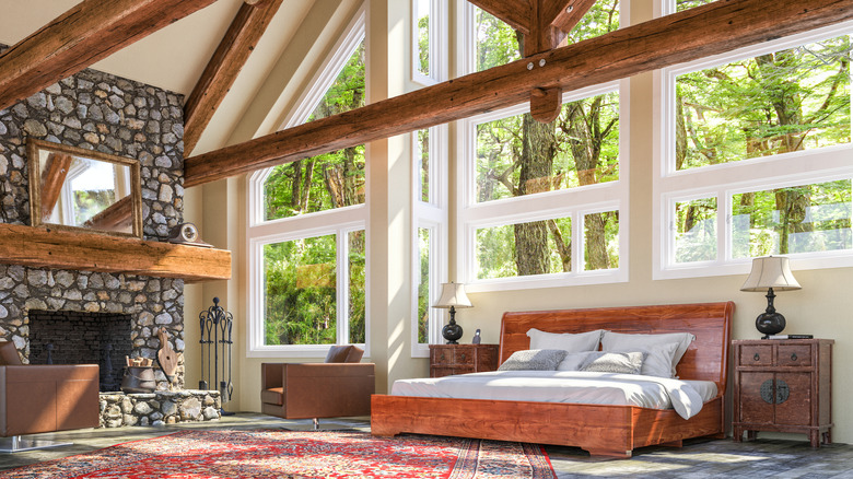 A bedroom with prominent wooden beams and wooden bedframe.