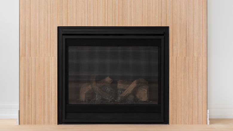 A fireplace with a tambour wall accent.