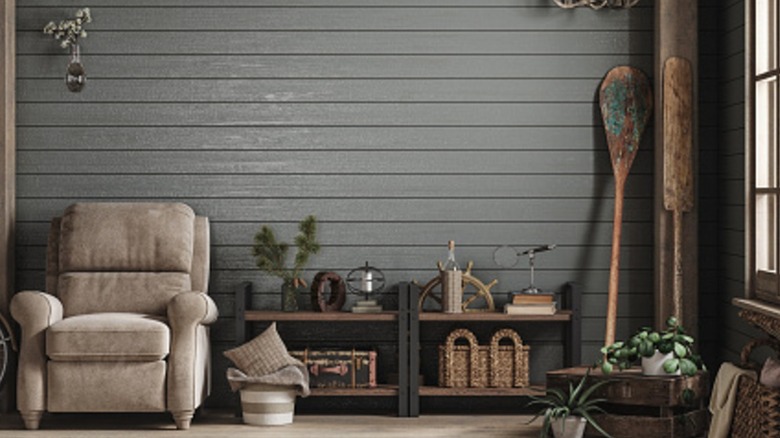A living room with painted shiplap walls and rustic decor.