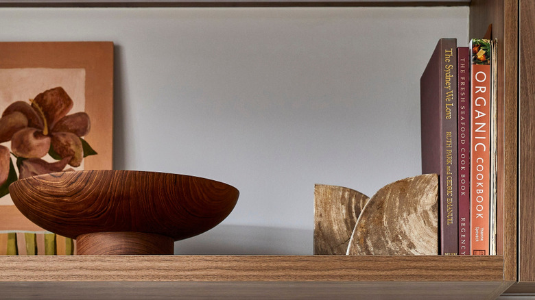 Cookbooks on shelf with bowl and artwork