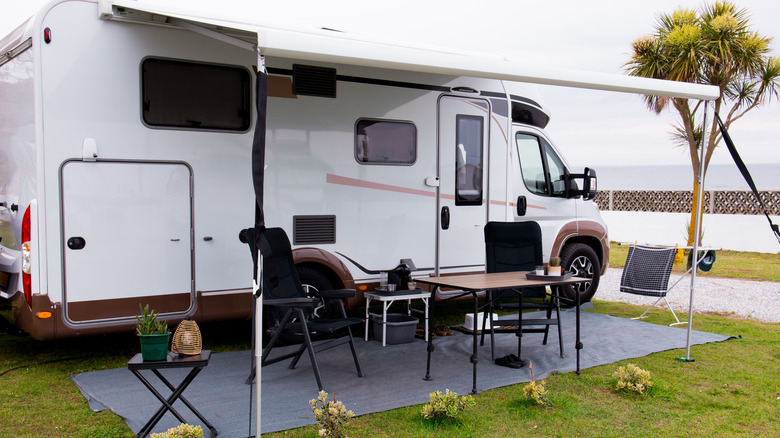 An RV with the outdoor seating area set up.