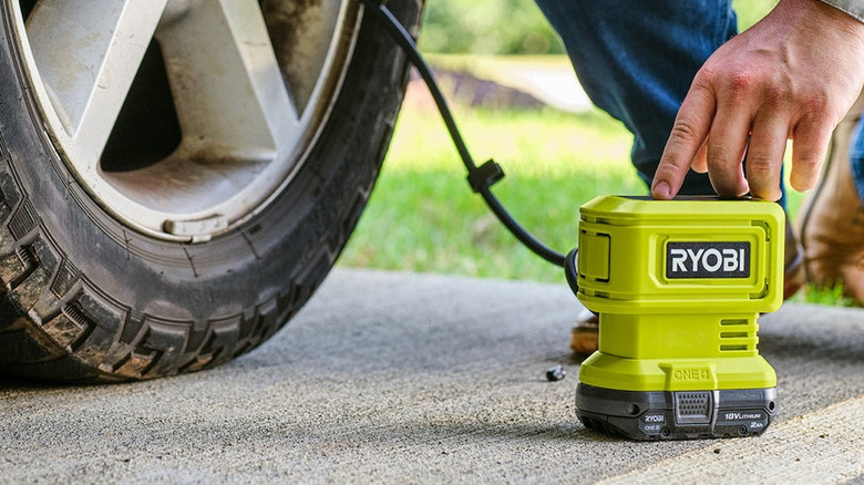 Someone using a Ryobi inflator to put air in tires
