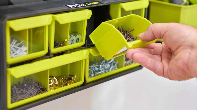 Someone opening up a compartment in a Ryobi small parts organizer