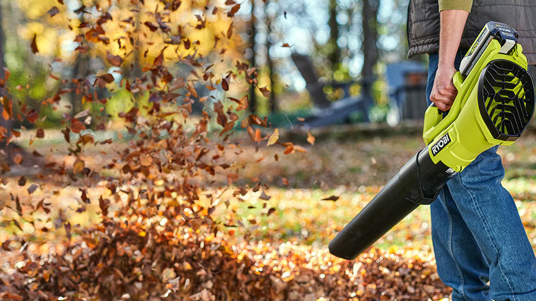 A gardener clearing leaves with Ryobi's 40V Cordless Battery Leaf Blower