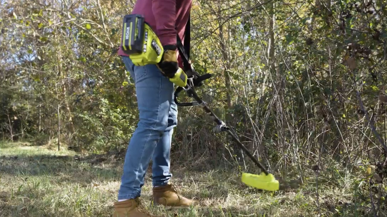A gardener using Ryobi's Expand-It Cordless String Trimmer