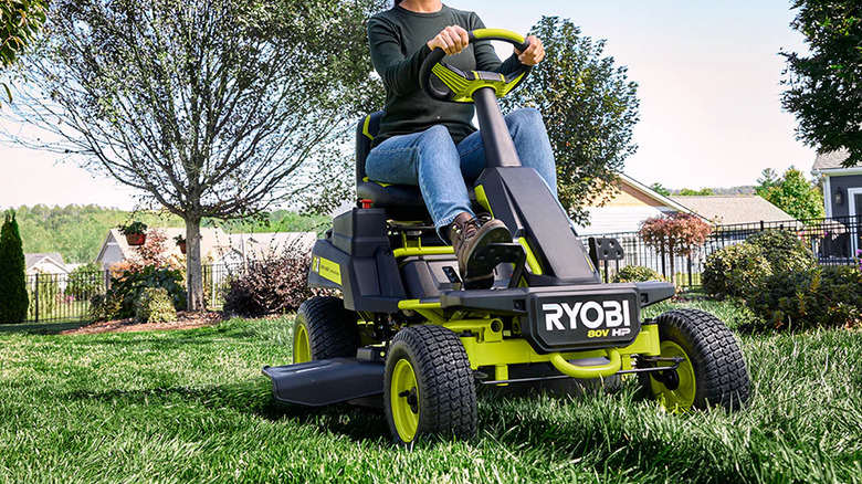 A person using Ryobi's 80V HP Brushless Cordless 30-inch Riding Lawn Mower