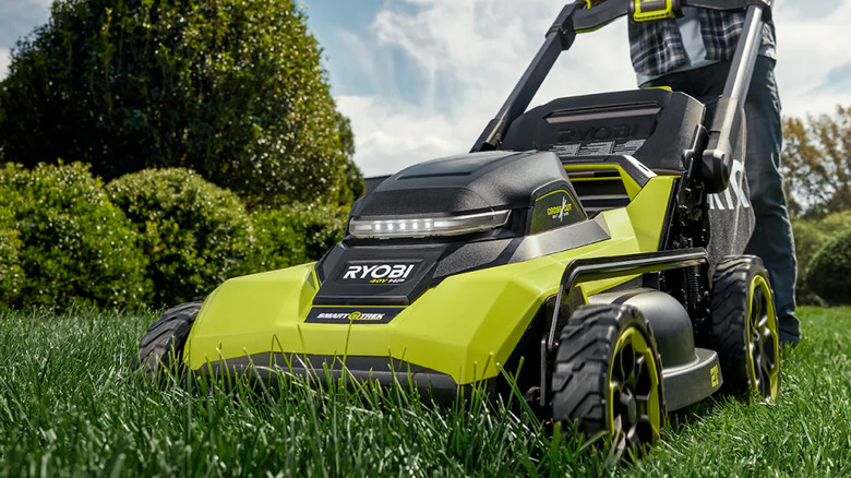 Close-up of a person using Ryobi's 40V HP Brushless 21-inch Cordless Walk Behind Mower