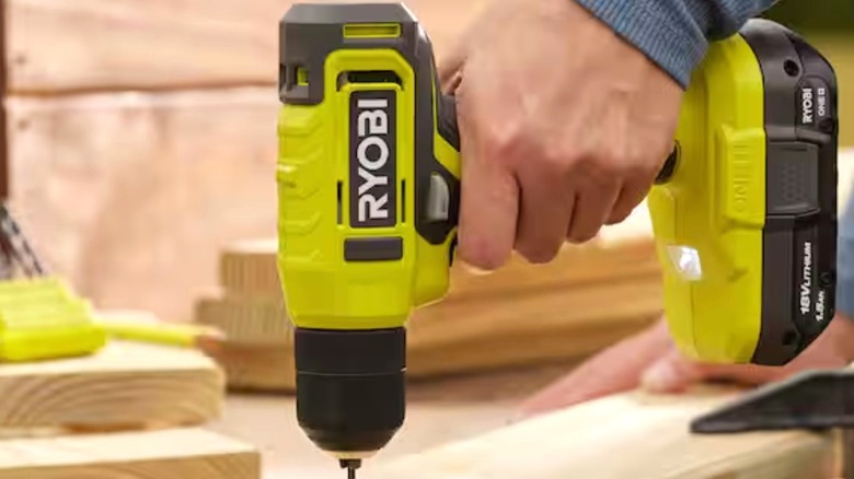 Person using Ryobi ONE+ cordless drill