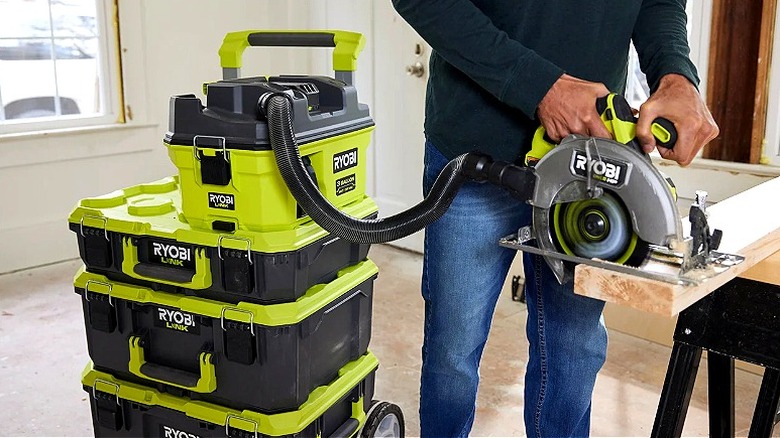 The Ryobi 18V One+ Link 3-Gallon Wet/Dry Vacuum collects sawdust from a Ryobi saw