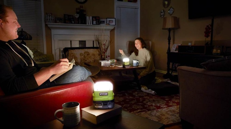 People using portable Ryobi lights in a darkened room