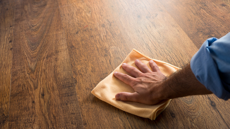 man running cloth across floor