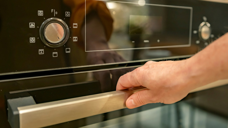 Hand on handle of an oven door