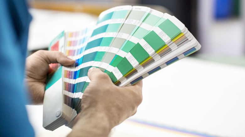 Close up of a man looking through greenish paint samples
