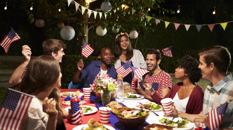 A multiracial group of friends celebrates the Fourth of July at a backyard party.