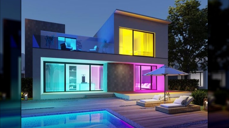 modern home exterior with colorful lights that can be seen from inside