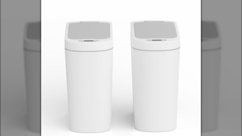 white motion sensor trash cans sitting side by side in gray-white room