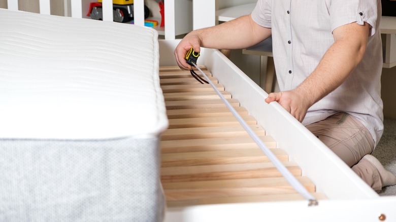 Man measuring a bed frame