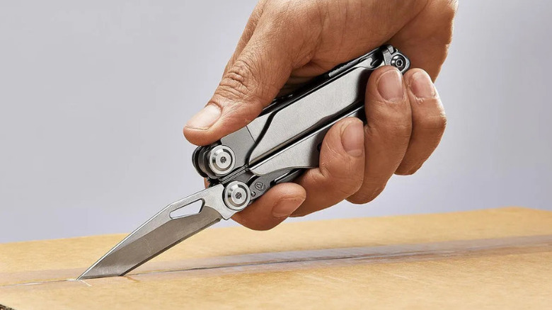 A man using Gordon's 20–in-1 Multi Tool to open a box