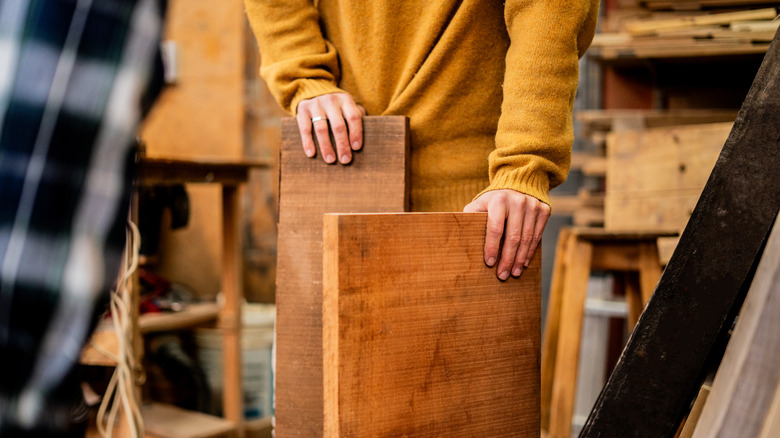 Carpenter holds pieces of scrap wood