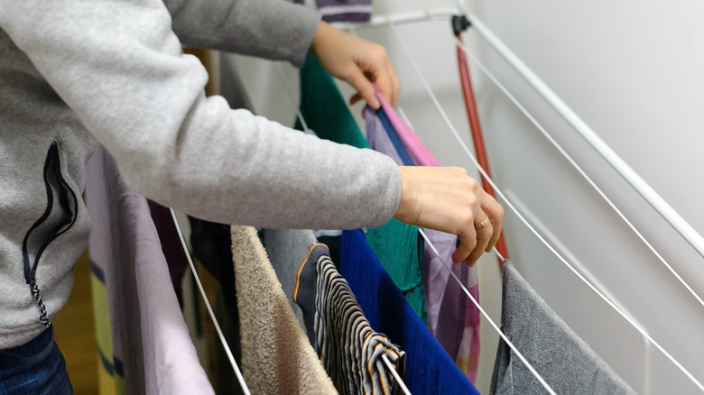 Woman hanging clothes on dryer