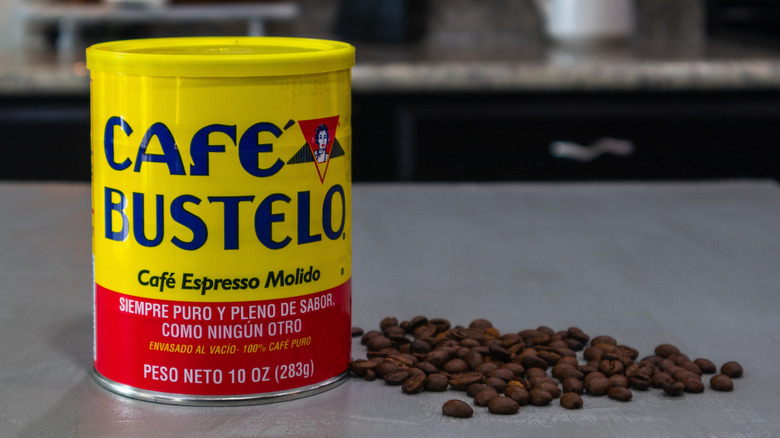 coffee canister on a counter with coffee beans next to it