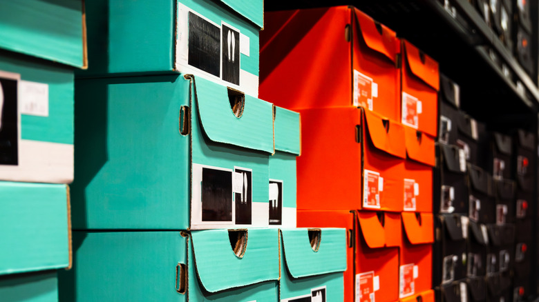Different color shoe boxes stacked up on store shelves.