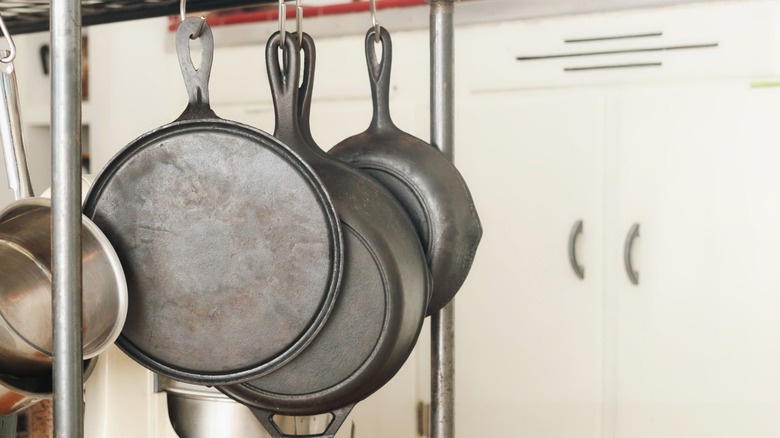 Cast iron skillets hanging from rack in kitchen