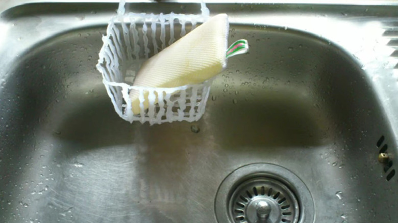 A sponge basket made from hot glue gun glue with a sponge sitting in it.