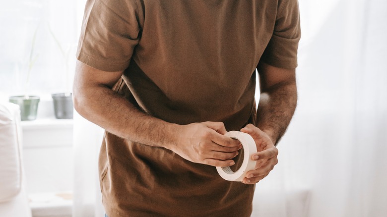 Man holding tape