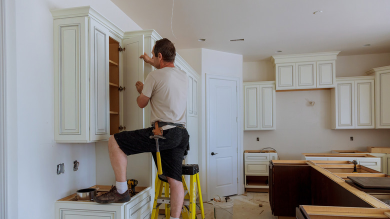 man working on kitchen cabinets