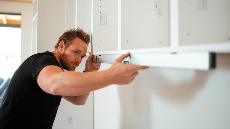 Person measuring and installing in garage