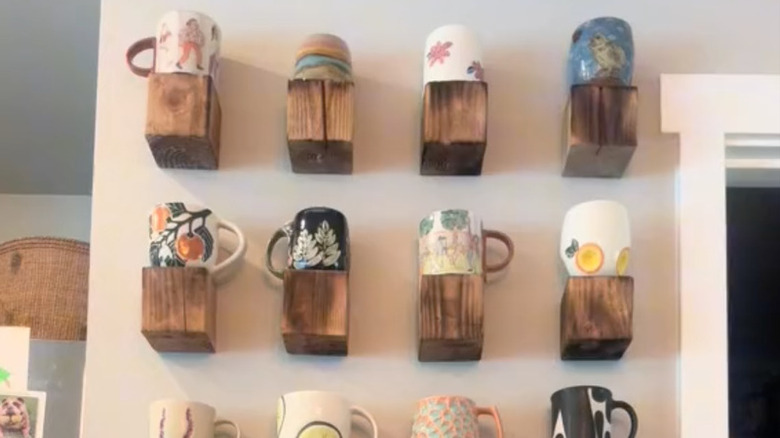 Individual mounted wood blocks on wall with coffee mugs displayed on top