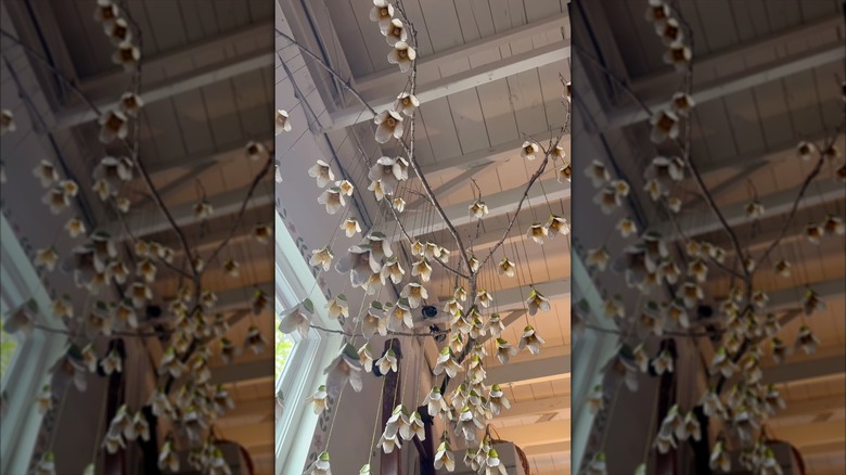 Cardboard flowers hanging from a stick from the ceiling