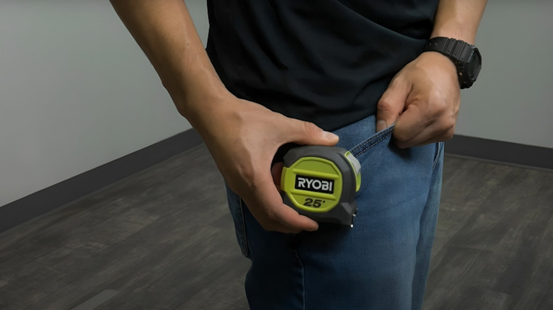 Man clipping tape measure pocket