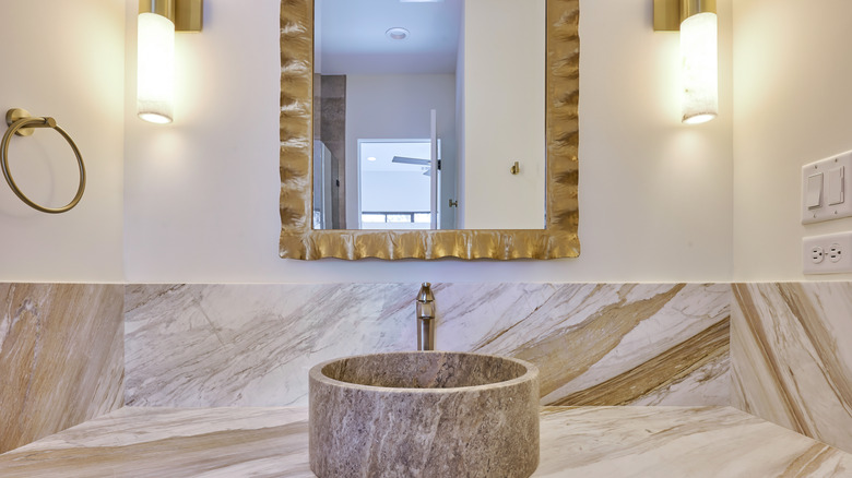Straight view of bathroom vanity sink and mirror with sconces.