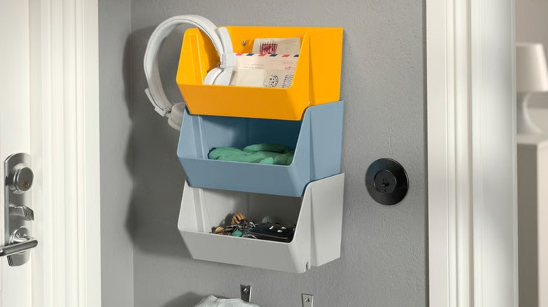 Three IKEA wall organizers stacked on top of each other in yellow, blue, and gray.