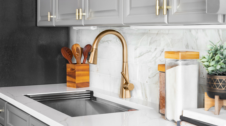 Kitchen counter with gold faucet and cabinet handles