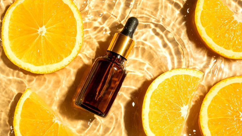 An essential oil bottle with orange slices