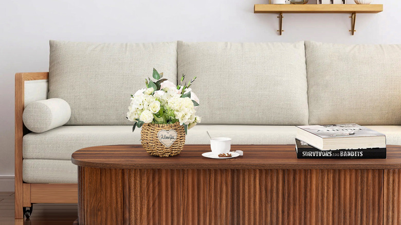 A fluted, walnut wood coffee table that lifts from Wayfair in front of a couch