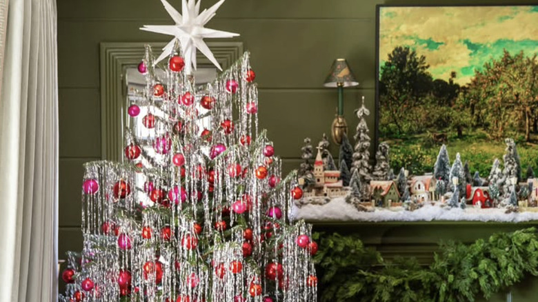 A tree with silver tinsel and pink and red ornaments