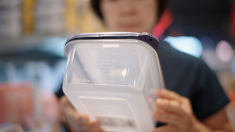 Person holding plastic food container