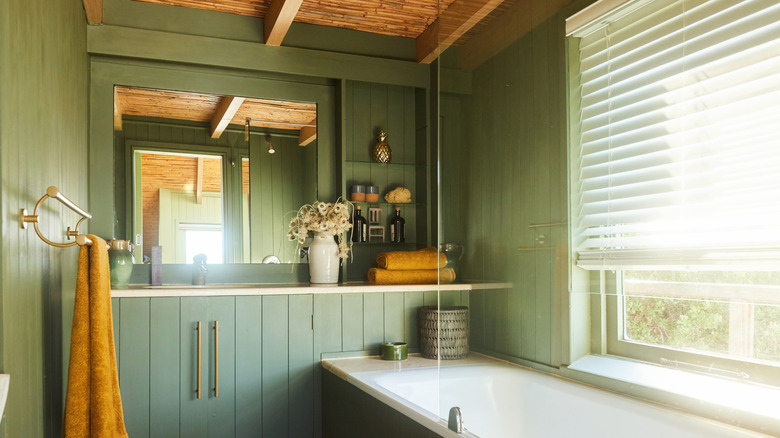 Dark and moody bathroom with wood paneling for a backsplash