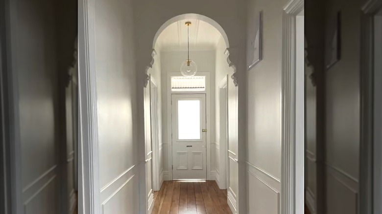 White plaster archway with corbels in home entryway.