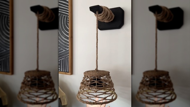 Hanging wall lamp with rope shade mounted on wall.
