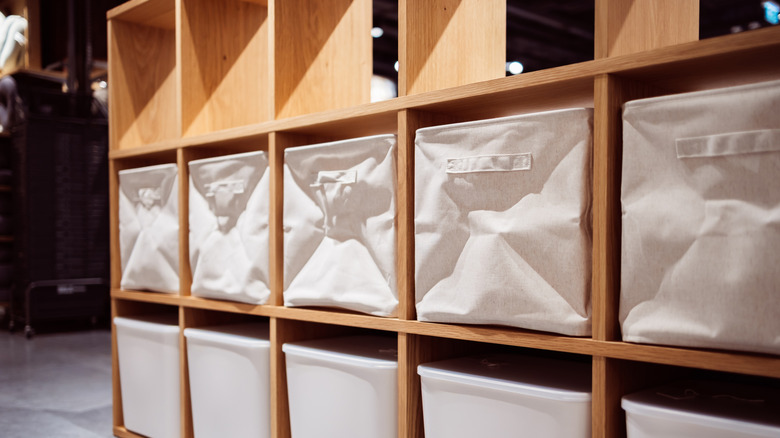 rows of white fabric bins in wooden cubbies