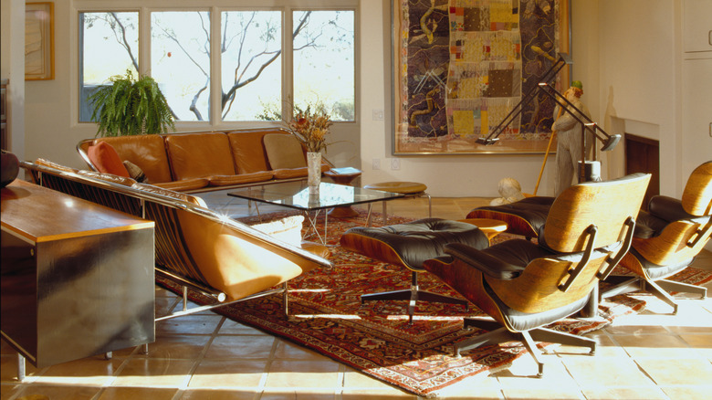 A room with two vintage orange couches with chrome accents