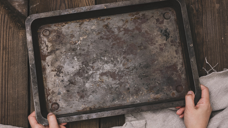 Person holding a burnt baking sheet