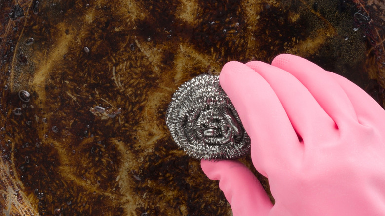 Person using steel wool on burnt pan