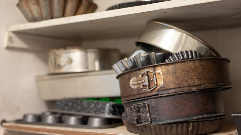 Stacked baking sheets and cake molds on shelves