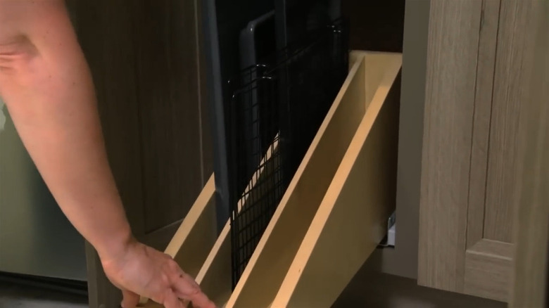 Person sliding out a pull-out baking tray divider